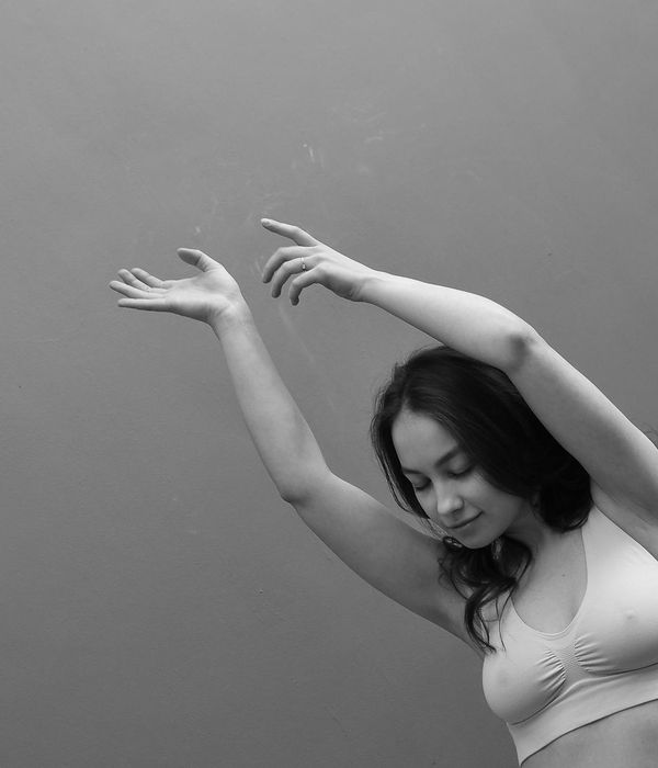 Woman in a graceful yoga pose, illuminated by soft lime light, focused and serene.