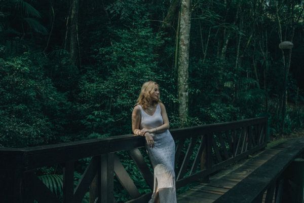 Woman meditating in a peaceful setting, surrounded by soft, natural light.